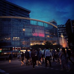 Crowd at illuminated city against sky at night