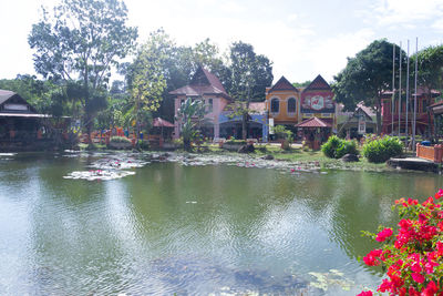 Scenic view of lake by buildings against sky