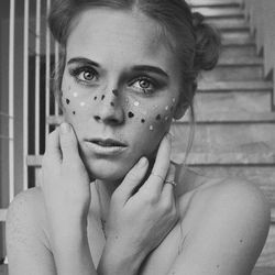 Portrait of woman with face paint against steps