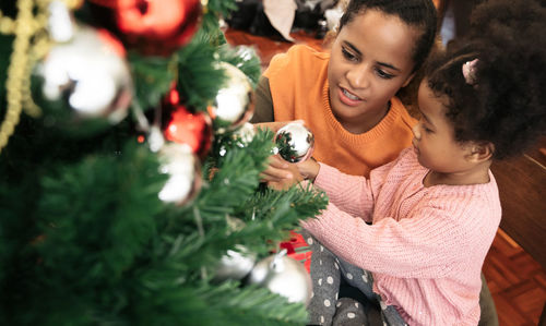 Portrait of smiling young woman with christmas tree