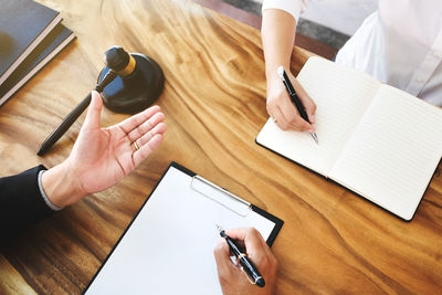 High angle view of woman reading book on table