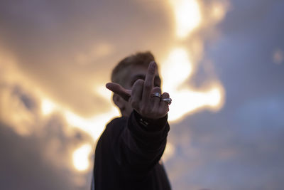 Portrait of a man covering his face with sky background