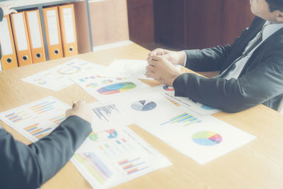 Businessmen with graphs at desk in office