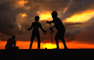 Silhouette of man standing against sunset