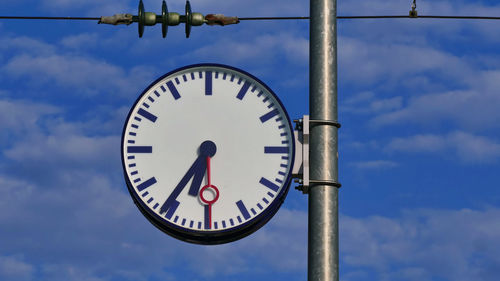 Low angle view of clock against sky