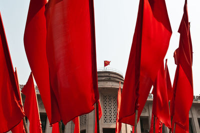 Low angle view of flags hanging against buildings in hanoi