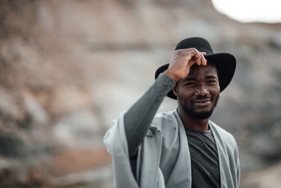 Portrait of young man wearing hat standing outdoors