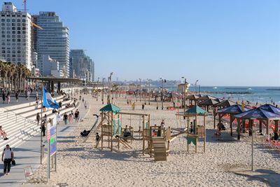 Group of people on beach against clear sky