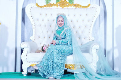 Portrait of the young bride sitting on the aisle chair