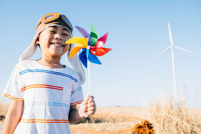 Low angle view of woman holding colorful balloons on field