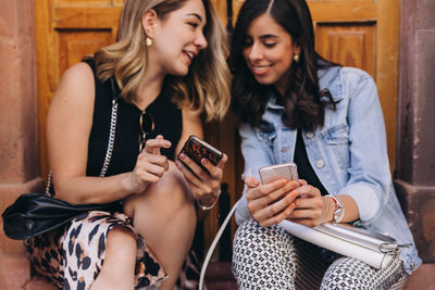 Young woman using mobile phone at camera