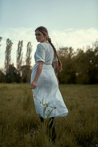 Woman standing on field against sky