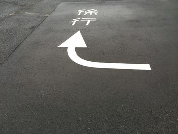 Arrow sign on road in city