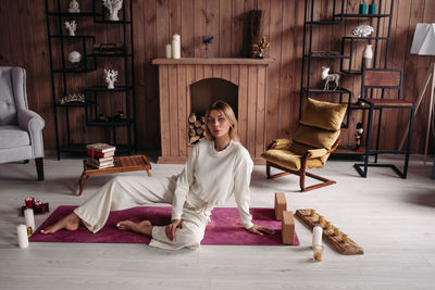 Portrait of young woman sitting on floor at home