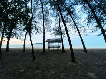 Empty chair on beach against sky