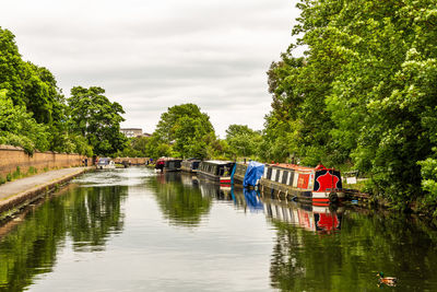 People on boat in river against sky on grand canal union, hanwell in london.
