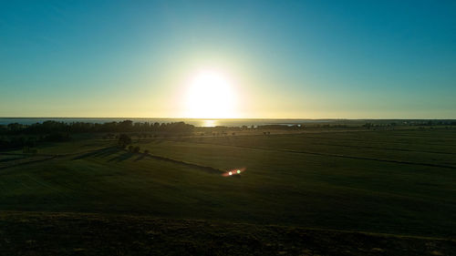 Scenic view of agricultural field against sky during sunset