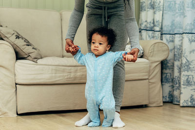 Full length of cute baby girl on sofa at home