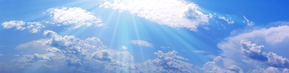 Blue sky with white clouds and sunbeams