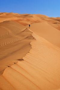 Sand dunes in desert against clear sky