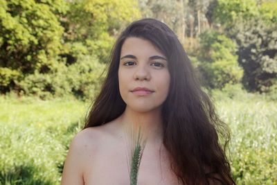 Portrait of shirtless woman on land