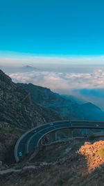 Scenic view of bridge over mountains against blue sky