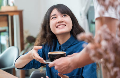 Portrait of a smiling young woman holding ice cream