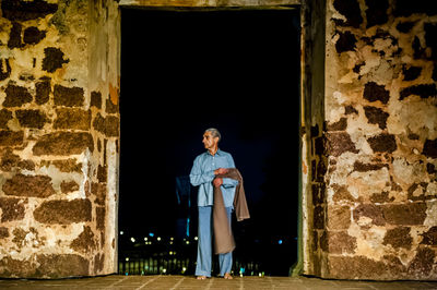 Portrait of a young man standing on railing