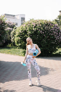 Athletic happy healthy young woman in sportswear goes after a sports workout exercise in nature