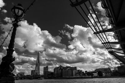 Low angle view of communications tower against cloudy sky