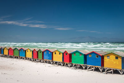 Multi colored umbrellas on beach against blue sky