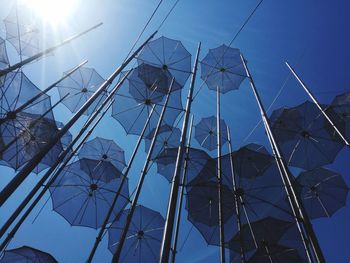 Low angle view of umbrellas against blue sky