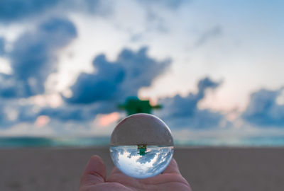 Close-up of hand holding crystal ball