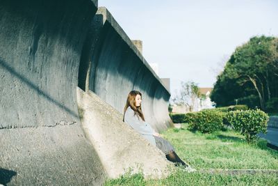 Thoughtful young woman by wall