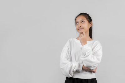 Portrait of a smiling young woman against white background