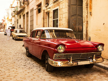 Vintage car on street against buildings in city