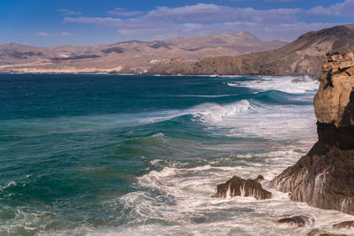 Scenic view of sea and mountains against sky