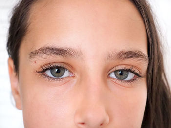 Portrait beautiful young caucasian tanned girl on white closeup long eyelash natural brown eyebrows