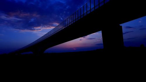 Low angle view of silhouette bridge against sky at sunset