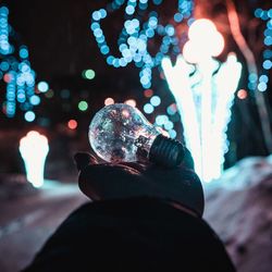 Low section of person with illuminated light bulb
