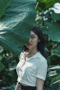 Portrait of beautiful woman standing with leaves