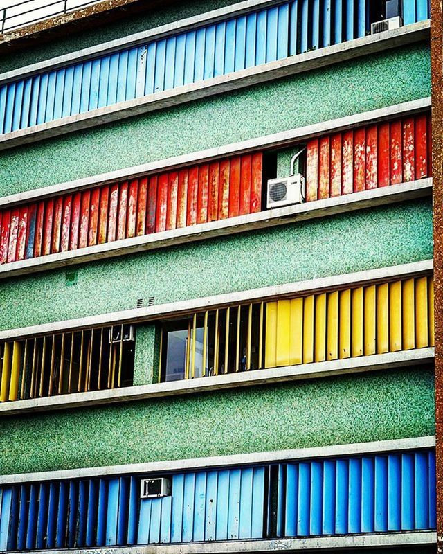 building exterior, architecture, built structure, multi colored, in a row, window, building, colorful, side by side, balcony, residential structure, residential building, city, day, outdoors, repetition, facade, blue, house, low angle view