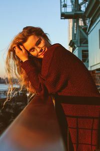 Portrait of young woman in front of building