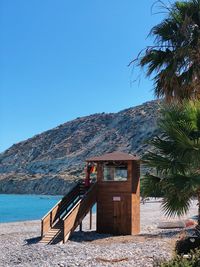 Built structure by sea against clear blue sky