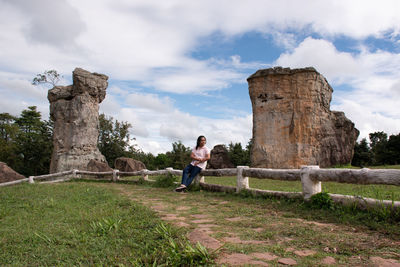 Man standing by stone wall against sky