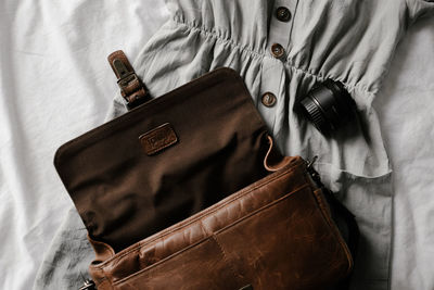 Directly above shot of leather bag and dress on sheet