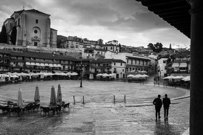 People on street by buildings against sky in city