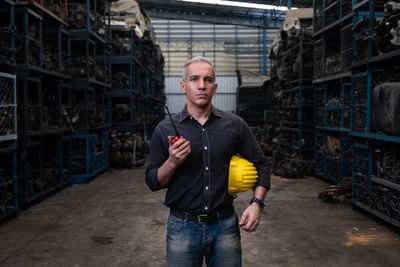 Portrait of young man standing in factory