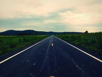 Empty road along countryside landscape