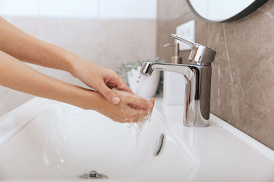 Washing hands under the flowing water tap. washing hands rubbing with soap for corona virus